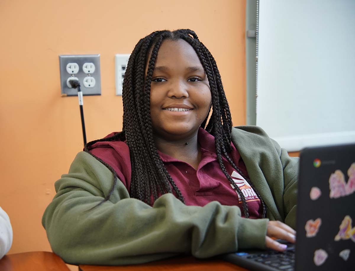 Elementary student smiling and posing together in a classroom.