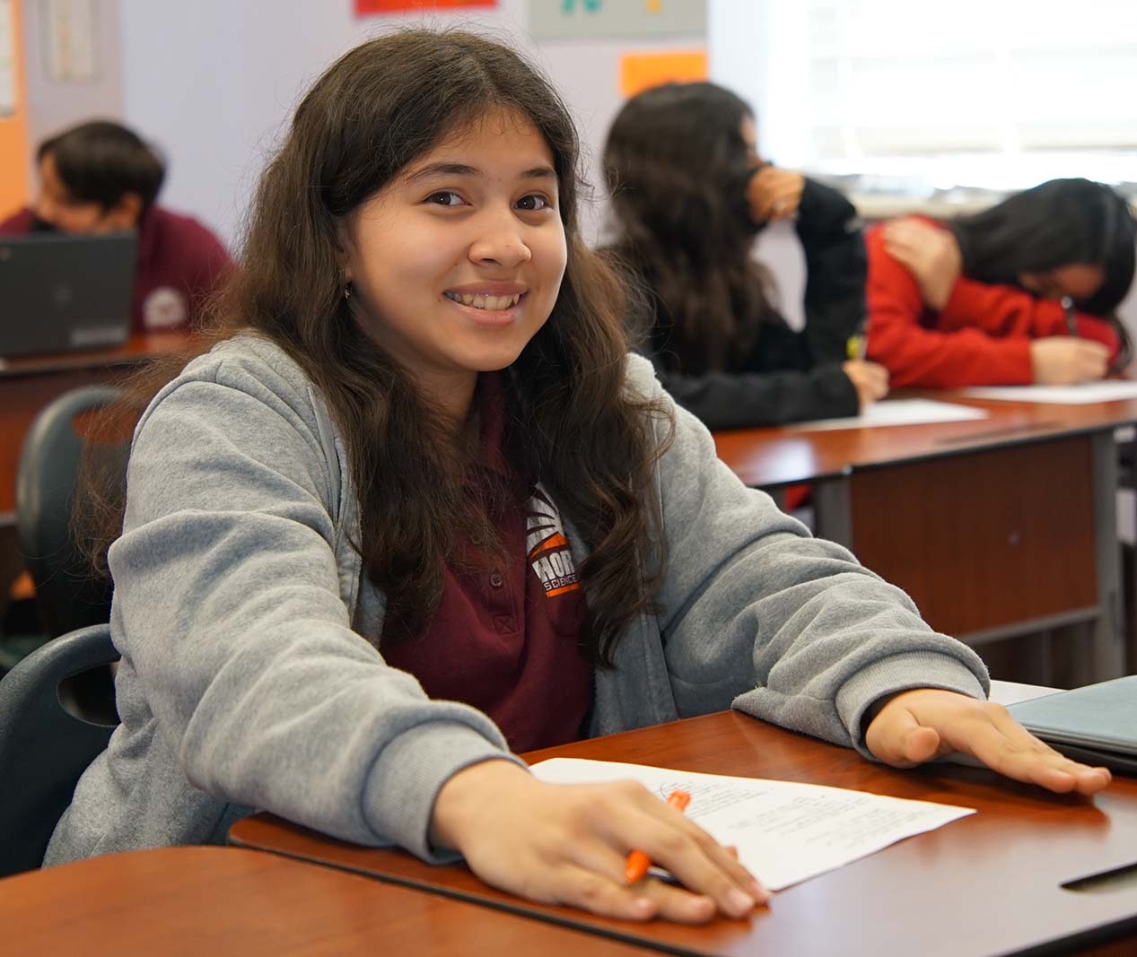 Student working on a notebook in a classroom.